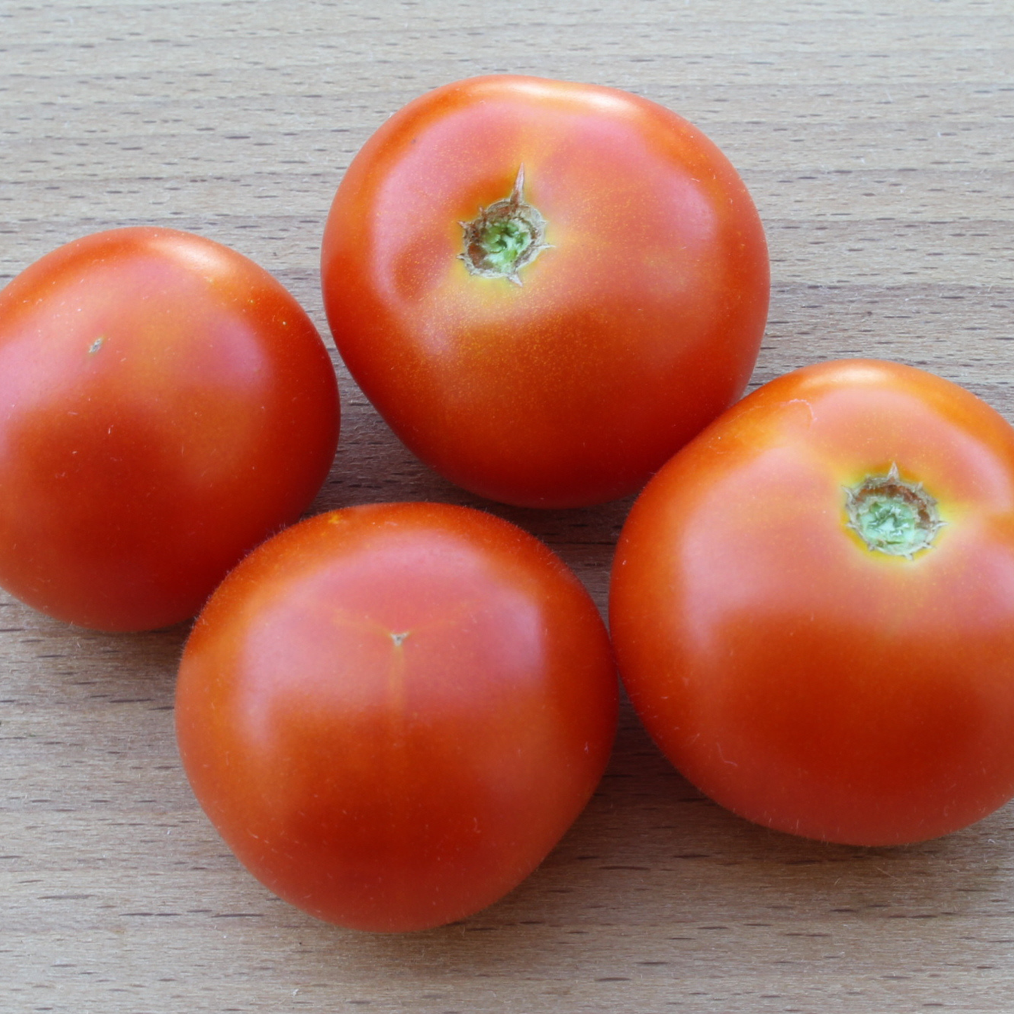 Close-up of ripe Florida Petite micro dwarf cherry tomatoes displayed on a wooden table.