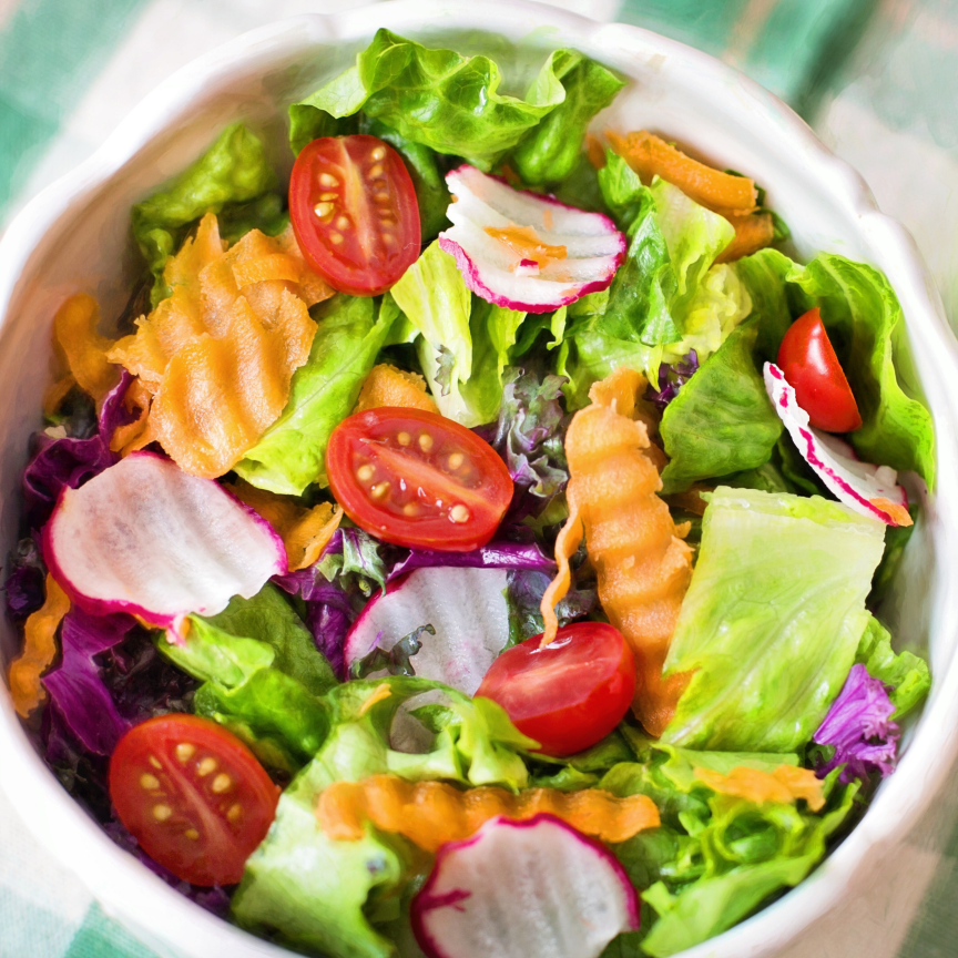 Fresh garden salad made with Grand Rapids leaf lettuce, tomatoes, carrots, and radishes