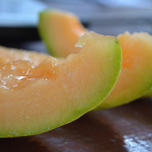 Close-up of a slice of cantaloupe on a dark surface